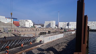 Foto van de werfwerkzaamheden voor de aanleg van de kademuur en kraanbaan bij City Terminal Kramer in de Prins Willem‑Alexanderhaven.