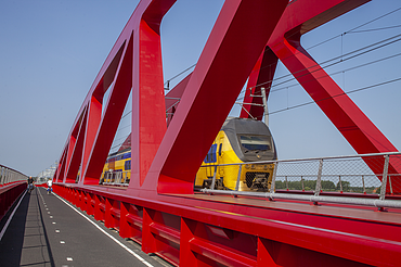 Een foto van de nieuwe spoorbrug, ook wel de Rode Brug of de Rode Loper genoemd, over de IJssel tussen Zwolle en Hattem