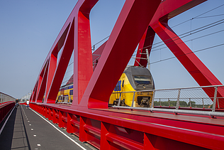 Een foto van de nieuwe spoorbrug, ook wel de Rode Brug of de Rode Loper genoemd, over de IJssel tussen Zwolle en Hattem