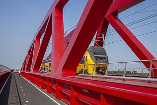 Een foto van de nieuwe spoorbrug, ook wel de Rode Brug of de Rode Loper genoemd, over de IJssel tussen Zwolle en Hattem