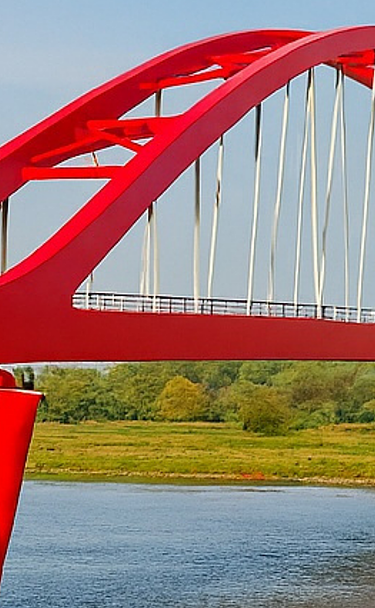 Een foto van de nieuwe spoorbrug, ook wel de Rode Brug of de Rode Loper genoemd, over de IJssel tussen Zwolle en Hattem