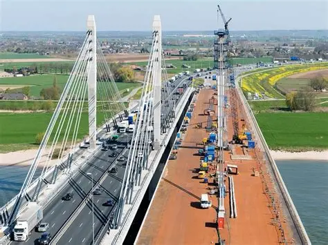 Een foto van de Brug over de Waal/Tacticusbrug, een stalen tuibrug van kokerliggers die de Waal bij Ewijk overspant.