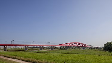 Een foto van de nieuwe spoorbrug, ook wel de Rode Brug of de Rode Loper genoemd, over de IJssel tussen Zwolle en Hattem