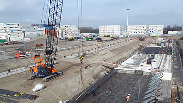 Foto van de werfwerkzaamheden voor de aanleg van de kademuur en kraanbaan bij City Terminal Kramer in de Prins Willem‑Alexanderhaven.