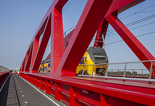 Een foto van de nieuwe spoorbrug, ook wel de Rode Brug of de Rode Loper genoemd, over de IJssel tussen Zwolle en Hattem