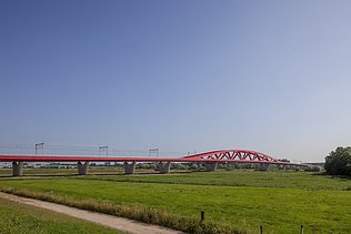 Een foto van de nieuwe spoorbrug, ook wel de Rode Brug of de Rode Loper genoemd, over de IJssel tussen Zwolle en Hattem