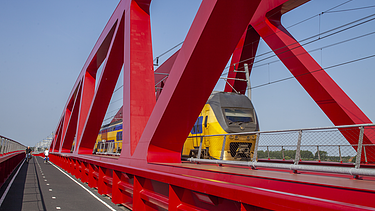 A photograph of the new railway bridge, also known as the Red Bridge or the Red Carpet, spanning the River IJssel between Zwolle and Hattem